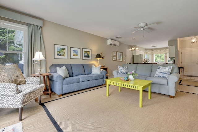 2 Round Cove Ln Unit 2, Phippsburg, ME 04562 - living room featuring a wall mounted AC, ceiling fan, healthy amount of natural light, and a chandelier