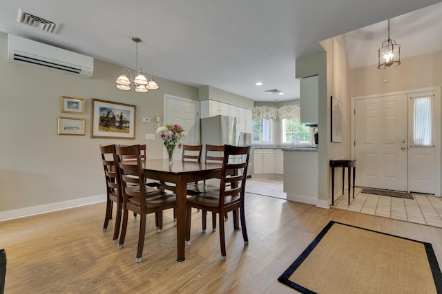 2 Round Cove Ln Unit 2, Phippsburg, ME 04562 - dining space with a wall mounted AC, a chandelier, light wood finished floors, baseboards, and recessed lighting