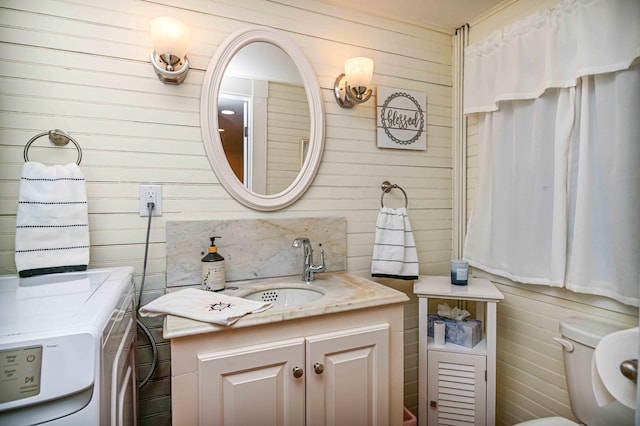 17 Bank Rd, York, ME 03909 - bathroom with independent washer and dryer, wood walls, vanity, and toilet