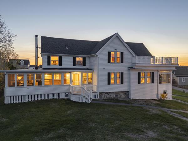 17 Bank Rd, York, ME 03909 - back of property at dusk featuring a balcony and a yard