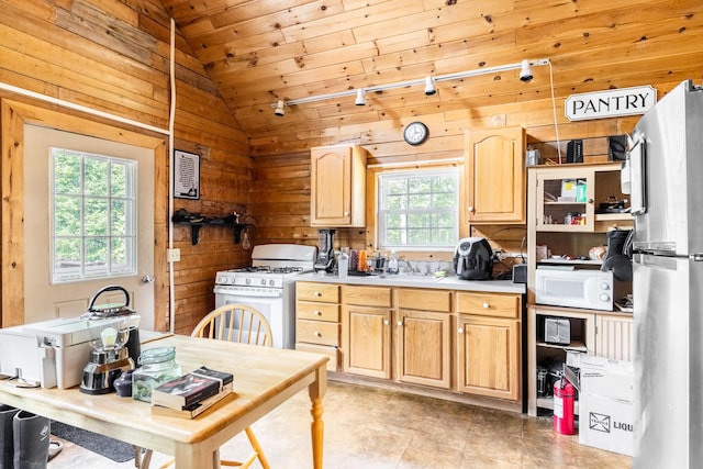 639 Main St, Springfield, ME 04487 - kitchen featuring white appliances, wood walls, vaulted ceiling, light brown cabinetry, and wood ceiling