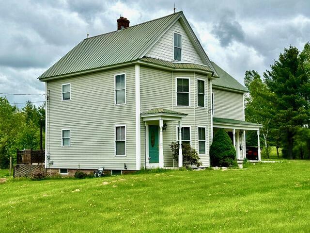 224 E Waterman Rd, Auburn, ME 04210 - back of property with a chimney, a yard, and metal roof