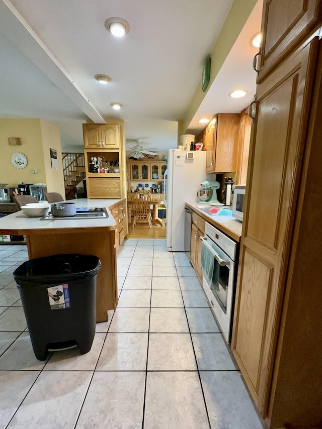 224 E Waterman Rd, Auburn, ME 04210 - kitchen with white appliances, light countertops, light tile patterned flooring, ceiling fan, and a peninsula