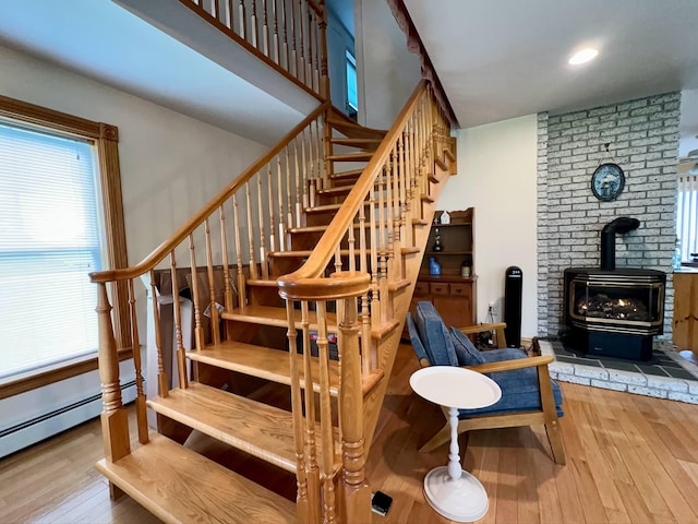 224 E Waterman Rd, Auburn, ME 04210 - staircase with a wood stove, wood-type flooring, a baseboard heating unit, and recessed lighting