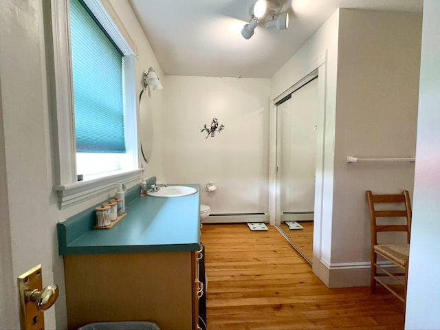 224 E Waterman Rd, Auburn, ME 04210 - bathroom with a baseboard radiator, toilet, vanity, and wood finished floors