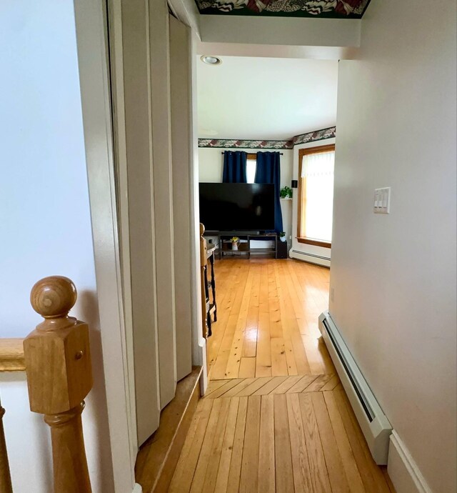 224 E Waterman Rd, Auburn, ME 04210 - hallway with a baseboard heating unit and light wood-style flooring