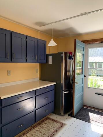 38 Cove Ln, Union, ME 04862 - kitchen featuring freestanding refrigerator, light countertops, decorative light fixtures, light flooring, and blue cabinets