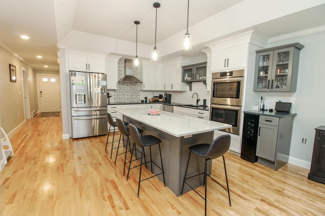 9 Camden Ct Unit 9, Bangor, ME 04401 - kitchen with appliances with stainless steel finishes, wall chimney range hood, a sink, a kitchen breakfast bar, and tasteful backsplash