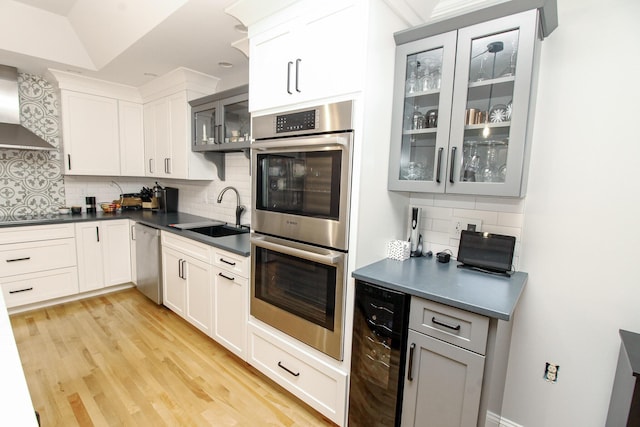 9 Camden Ct Unit 9, Bangor, ME 04401 - kitchen with wine cooler, a sink, stainless steel appliances, decorative backsplash, and wall chimney range hood