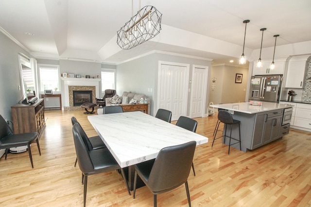 9 Camden Ct Unit 9, Bangor, ME 04401 - dining room with light wood-style floors, ornamental molding, a glass covered fireplace, and a raised ceiling