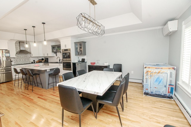 9 Camden Ct Unit 9, Bangor, ME 04401 - dining area featuring a baseboard radiator, an AC wall unit, light wood finished floors, a raised ceiling, and crown molding