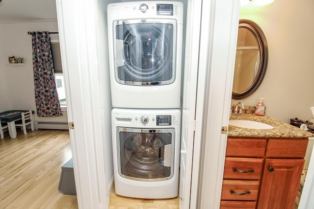 9 Camden Ct Unit 9, Bangor, ME 04401 - laundry area with stacked washer and clothes dryer, baseboard heating, and light wood-style floors