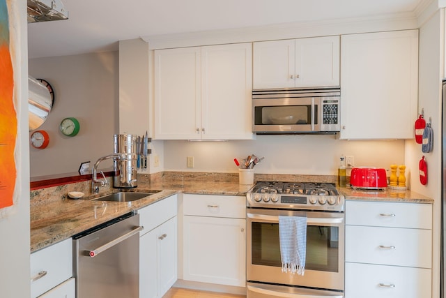 311 Chandlers Wharf Unit 311, Portland, ME 04101 - kitchen featuring stainless steel appliances, a sink, white cabinetry, light stone counters, and a peninsula