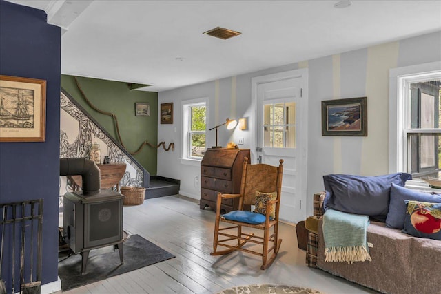 637 Falls Bridge Rd, Blue Hill, ME 04614 - living area featuring wood-type flooring, a wood stove, stairs, and baseboards