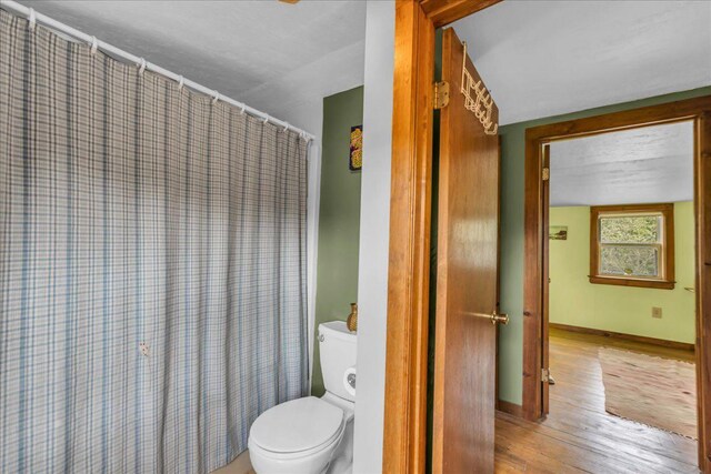 637 Falls Bridge Rd, Blue Hill, ME 04614 - bathroom with toilet, wood finished floors, baseboards, and a shower with curtain