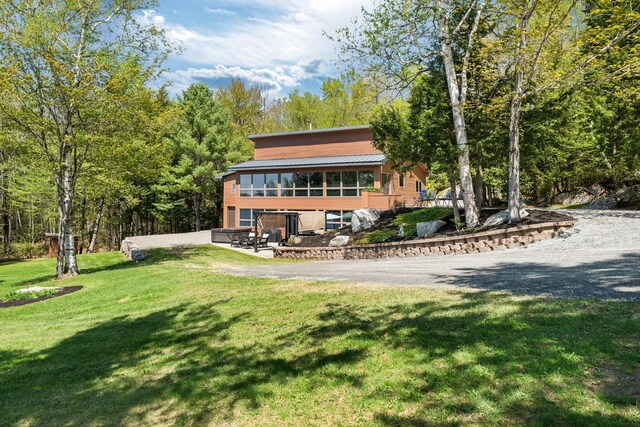 36 Sunset Dr, Saint Albans, ME 04971 - back of property with a lawn, a forest view, and metal roof