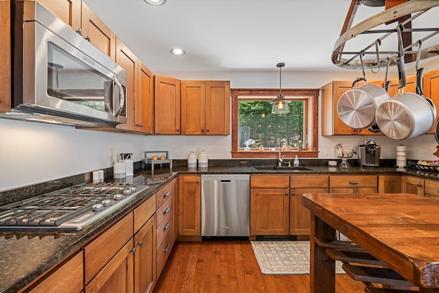 36 Sunset Dr, Saint Albans, ME 04971 - kitchen featuring stainless steel appliances, a sink, dark wood-style flooring, brown cabinets, and pendant lighting