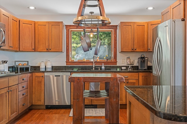 36 Sunset Dr, Saint Albans, ME 04971 - kitchen with stainless steel appliances, a sink, light wood-type flooring, dark stone counters, and brown cabinetry