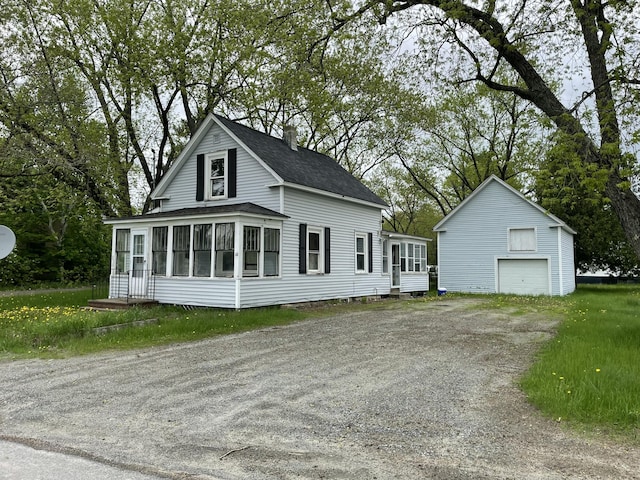 51 Parlin St, Skowhegan, ME 04976 - view of front facade with a sunroom, a garage, an outdoor structure, a shingled roof, and driveway