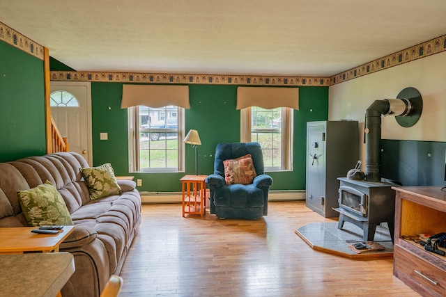 17 Easy St, Standish, ME 04084 - living area featuring hardwood / wood-style flooring, plenty of natural light, a baseboard heating unit, and a wood stove