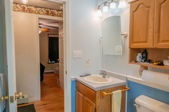 17 Easy St, Standish, ME 04084 - bathroom featuring vanity, toilet, wood finished floors, a baseboard radiator, and ceiling fan