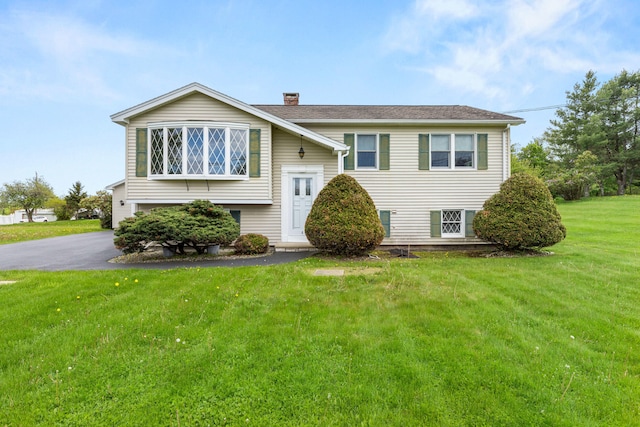 4 Shirley Ln, Gorham, ME 04038 - split foyer home featuring a chimney, a front yard, asphalt driveway, and an attached garage