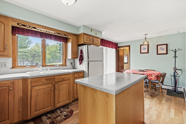 4 Shirley Ln, Gorham, ME 04038 - kitchen featuring freestanding refrigerator, a sink, light wood-style floors, and brown cabinetry