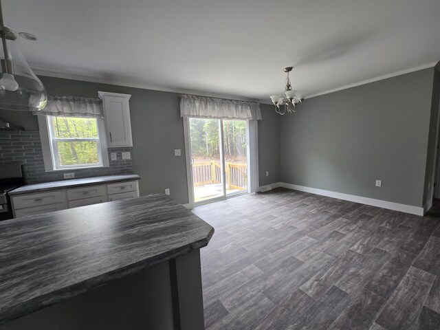 209 Sandy Acres Dr, Sullivan, ME 04664 - kitchen featuring a chandelier, dark countertops, healthy amount of natural light, ornamental molding, and dark wood-type flooring
