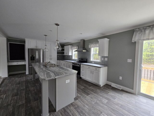 209 Sandy Acres Dr, Sullivan, ME 04664 - kitchen with stainless steel appliances, wall chimney exhaust hood, decorative backsplash, white cabinets, and a center island with sink