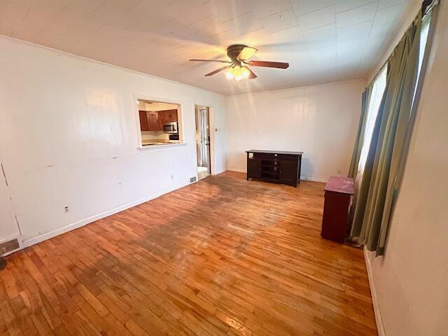 16 Pearce Ave, Houlton, ME 04730 - unfurnished living room featuring hardwood / wood-style floors, a ceiling fan, and baseboards