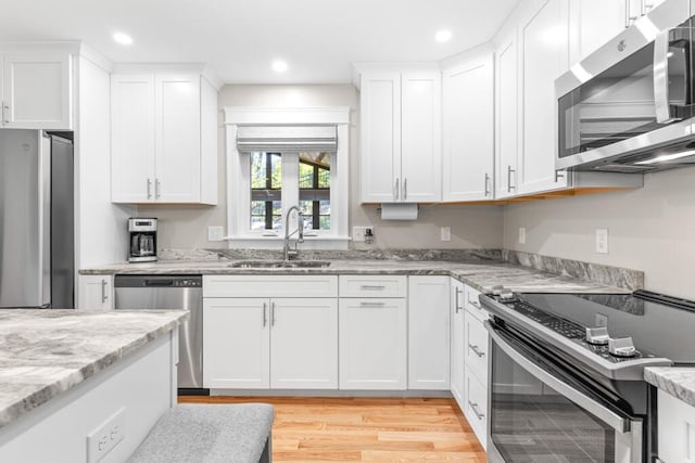 24 Kapok St, Old Orchard Beach, ME 04064 - kitchen featuring appliances with stainless steel finishes, a sink, white cabinetry, light wood-style floors, and recessed lighting