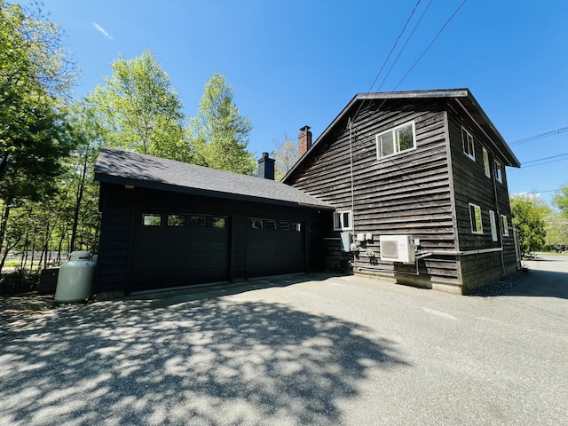 341 Ellsworth Rd, Blue Hill, ME 04614 - view of side of property featuring a chimney, a garage, an outdoor structure, and ac unit