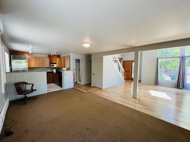 341 Ellsworth Rd, Blue Hill, ME 04614 - unfurnished living room with stairway, light colored carpet, baseboards, and light wood finished floors