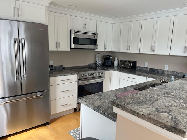 47 Ocean Ave Unit 6, Kennebunkport, ME 04046 - kitchen with appliances with stainless steel finishes, a sink, white cabinetry, light wood-style floors, and recessed lighting