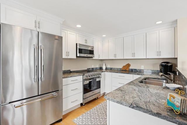 47 Ocean Ave Unit 6, Kennebunkport, ME 04046 - kitchen featuring appliances with stainless steel finishes, white cabinets, recessed lighting, and light stone counters