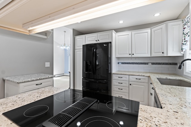 37 Longbow Ct, Auburn, ME 04210 - kitchen with black fridge, a sink, decorative backsplash, white cabinets, and light stone counters