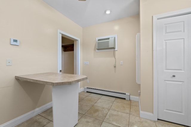 37 Longbow Ct, Auburn, ME 04210 - kitchen with a baseboard radiator, an AC wall unit, light tile patterned flooring, a peninsula, and baseboards