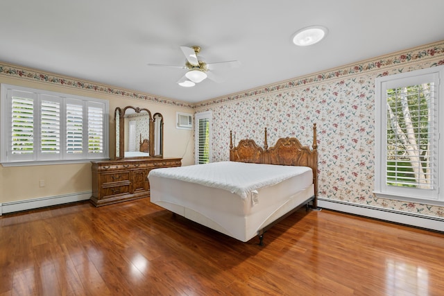 37 Longbow Ct, Auburn, ME 04210 - bedroom with baseboard heating, wood finished floors, wallpapered walls, and ceiling fan