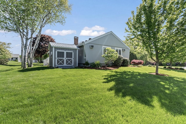 37 Longbow Ct, Auburn, ME 04210 - rear view of property featuring a yard, a chimney, and metal roof