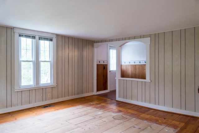 57 Bow St, Freeport, ME 04032 - unfurnished room featuring hardwood / wood-style floors, wooden walls, and arched walkways