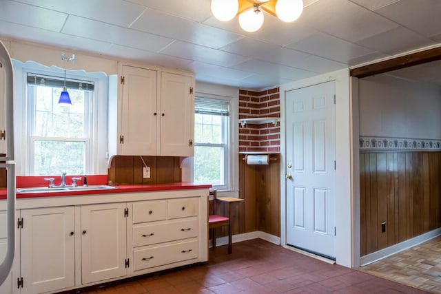 57 Bow St, Freeport, ME 04032 - kitchen with a sink, white cabinets, plenty of natural light, and wooden walls