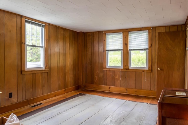 57 Bow St, Freeport, ME 04032 - unfurnished room with light wood finished floors, wood walls, and baseboards