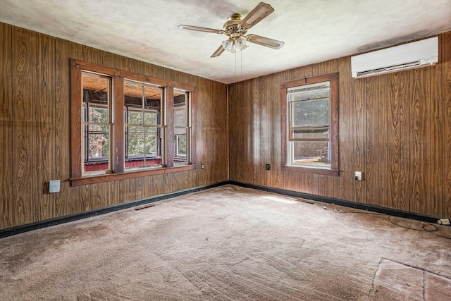 27 Maple St, Limerick, ME 04048 - carpeted empty room with a wall mounted AC, ceiling fan, wooden walls, and baseboards