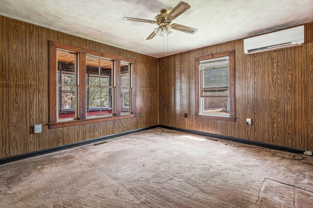 27 Maple St, Limerick, ME 04048 - carpeted empty room with a wall mounted AC, ceiling fan, wooden walls, and baseboards