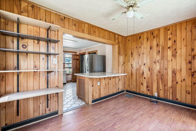 27 Maple St, Limerick, ME 04048 - kitchen featuring freestanding refrigerator, open shelves, wood walls, a ceiling fan, and wood finished floors