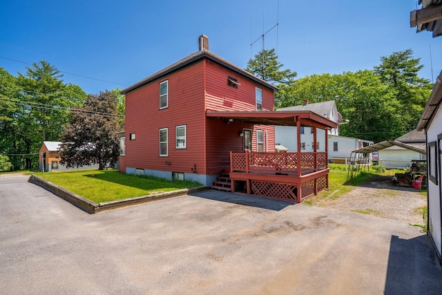 27 Maple St, Limerick, ME 04048 - view of front of house with a chimney, a front yard, and a wooden deck