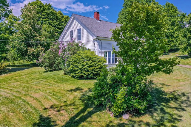 176 Bagley Hill Rd, Troy, ME 04987 - view of home's exterior with a chimney, a lawn, and roof with shingles