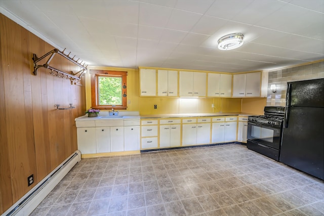 176 Bagley Hill Rd, Troy, ME 04987 - kitchen with black appliances, baseboard heating, cream cabinets, light countertops, and wood walls