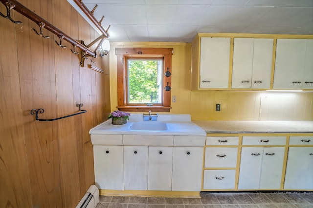 176 Bagley Hill Rd, Troy, ME 04987 - kitchen featuring light countertops, wood walls, a sink, and white cabinets