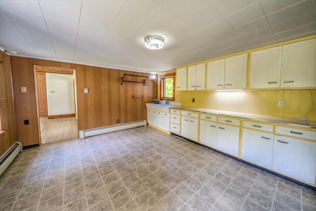 176 Bagley Hill Rd, Troy, ME 04987 - kitchen featuring baseboard heating, wood walls, baseboards, cream cabinets, and a sink